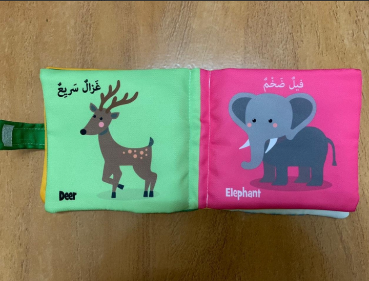 كتاب قماشي للأطفال يحتوي على صور حيوانات كوأسمائها باللغتين العربية والإنجليزية. يحتوي الكتاب على شريط إغلاق  وجيب جانبي يحمل لعبة قماشية مطابقة لإخراجها والضغط عليها لإصدار صوت صرير. المادة مخيطة بإحكام لتحمل الغسيل  الكتاب واللعبة خفيفان الوزن مع حشو ناعم، مما يسهل على الطفل  اللعب بهما 